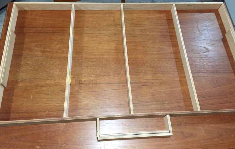The base/frame of the dollhouse laid out prior to assembly