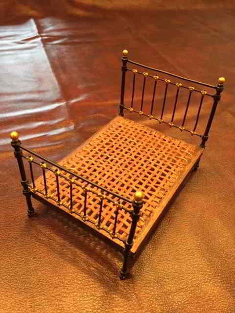 miniature brass bed showing wood and leather spring